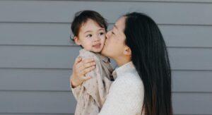 mom kissing a child on cheek